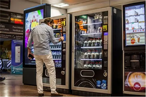 A man getting a drink from vending machine